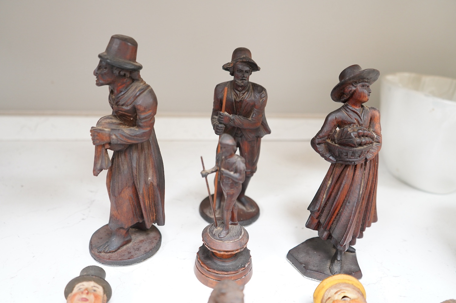 A collection of Black Forest wooden figurative carvings to include a pair of corbels in the form of musicians and a carved bear bottle stopper, largest 32cm high. Condition - mostly fair